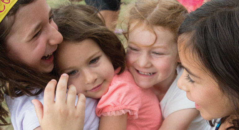 group of girl campers hugging each other