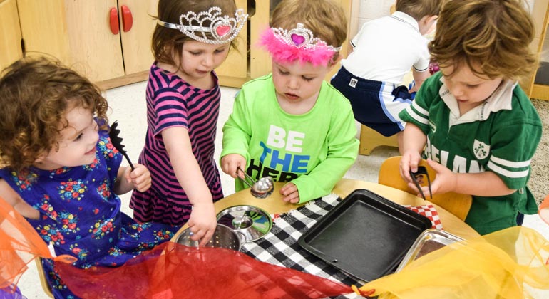 preschoolers playing with kitchen utensils