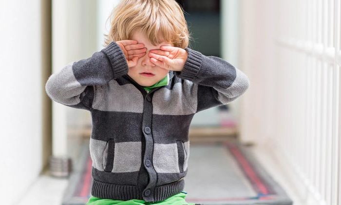 little boy covering eyes with hands