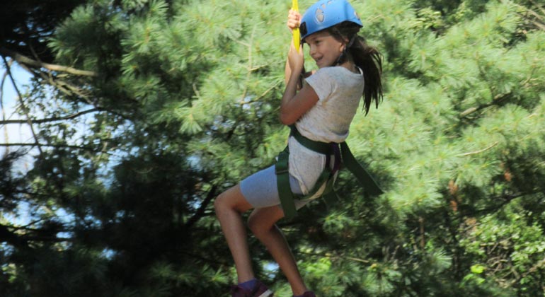 girl camper on zipline at camp chi