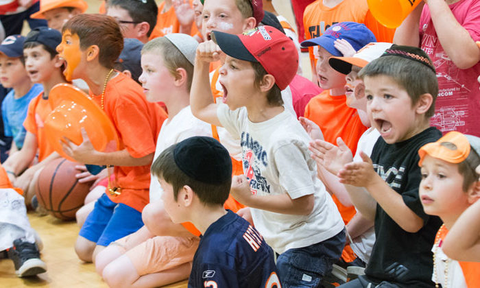 boy campers clapping and cheering at basketball game