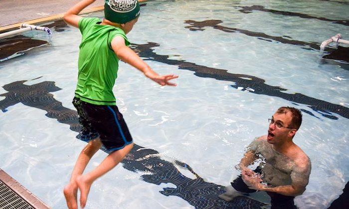 boy jumping into pool