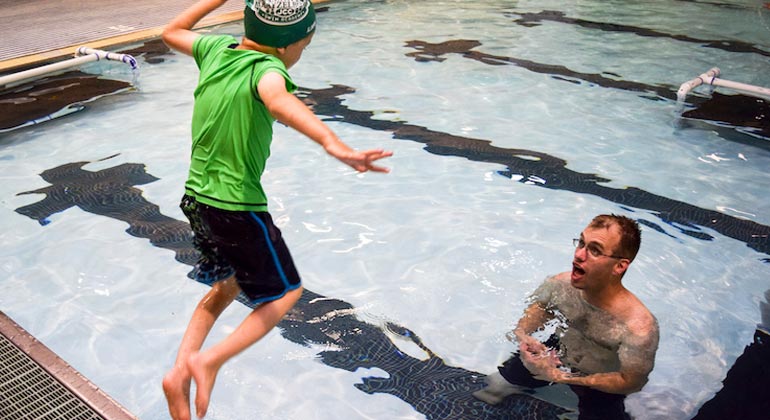 boy jumping into pool