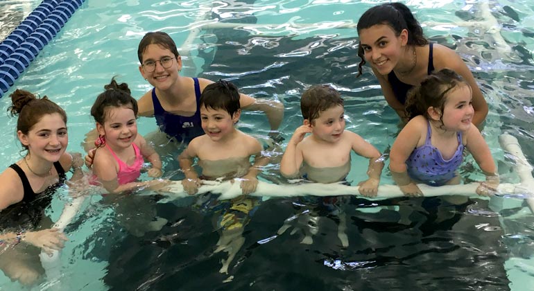 swim instructors with kids in pool