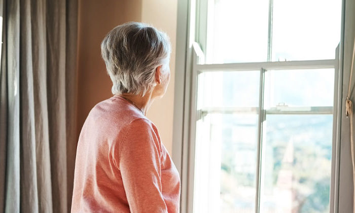 senior woman looking out a window