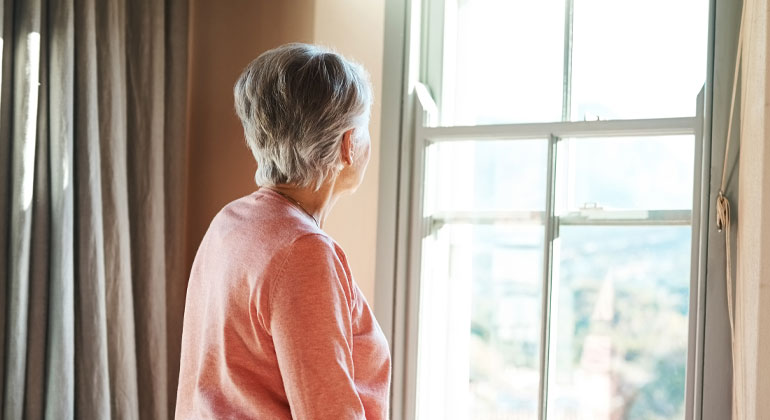 senior woman looking out a window