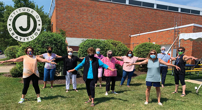 group of seniors wearing masks exercising outside