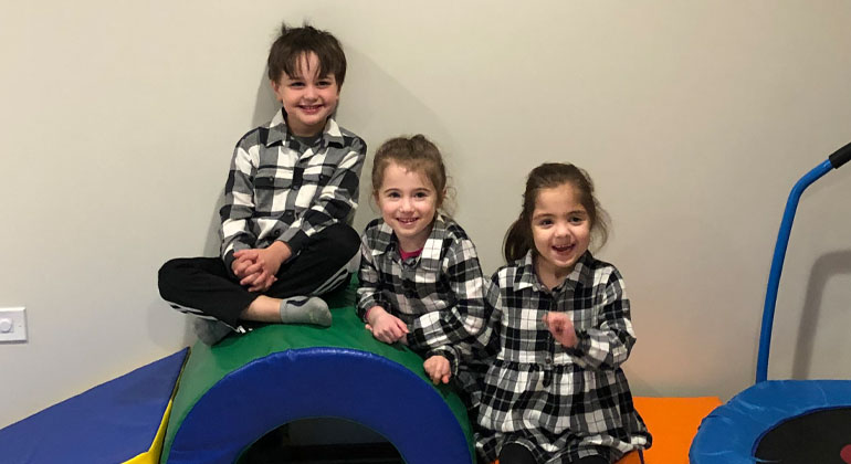 three early childhood students in matching flannel outfits