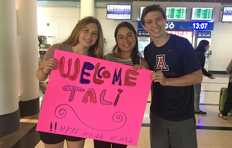 people waiting at the airport with sign
