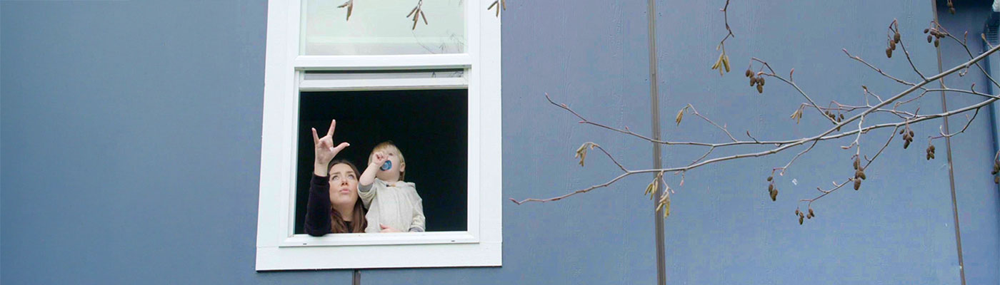 woman and child pointing while looking out a window
